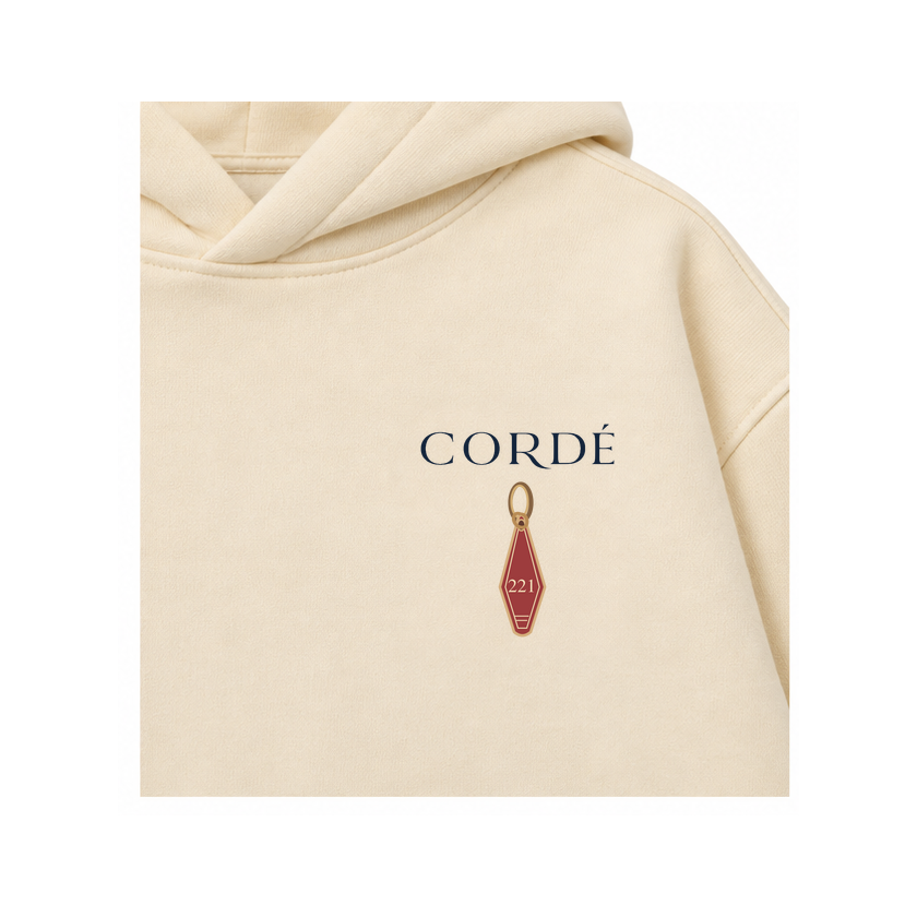 CORDÉ Cream hoodie, front detail: CORDÉ logo and room key 221.