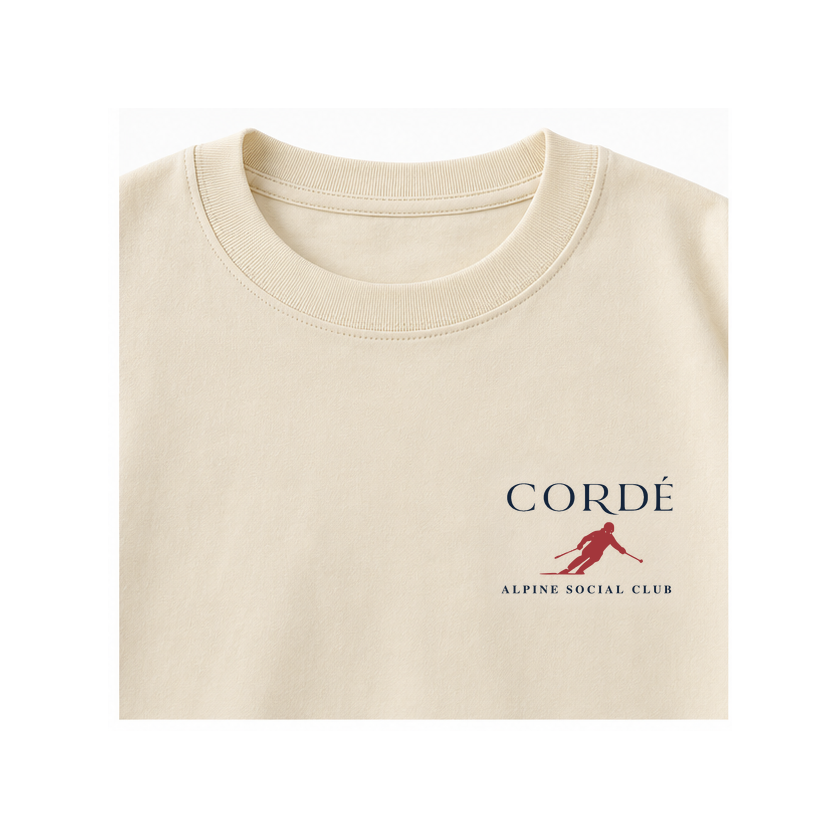 CORDÉ Cream longsleeve, front detail: CORDÉ logo and small red skier.