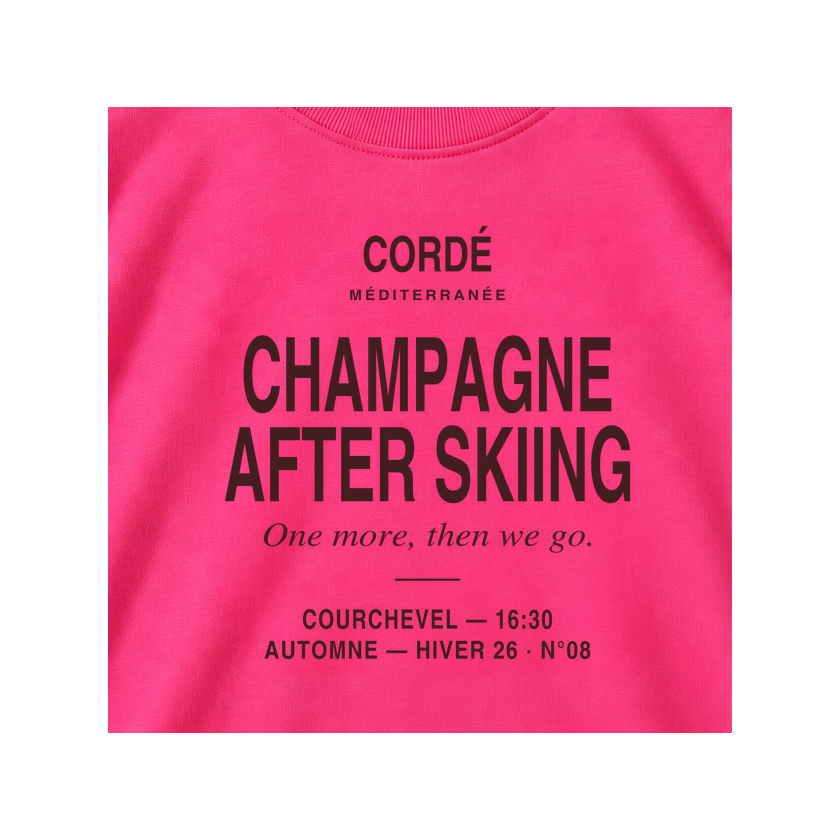 CORDÉ Hot Pink longsleeve, front detail: Champagne After Skiing lettering.
